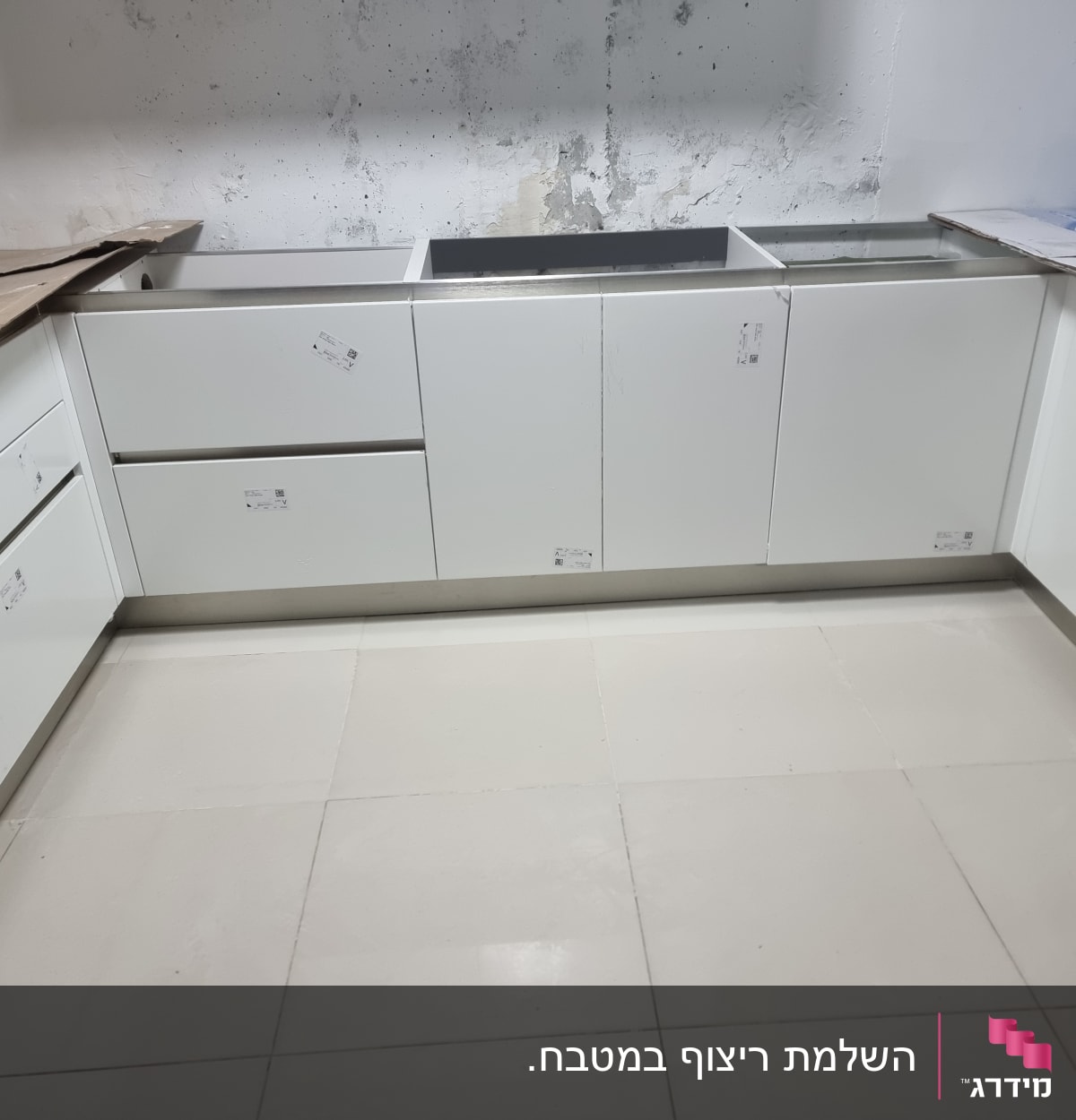 ארונות מטבח לבנים מותקנים בחלל שיפוץ